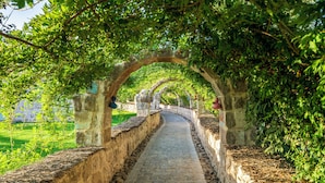 A stone pathway under an arched structure with greenery on either side. - AJWA Cappadocia - Preferred Hotels Legend Collection (Ürgüp)