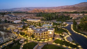 A large, well-lit building with a central courtyard, surrounded by landscaped areas and a road. - AJWA Cappadocia - Preferred Hotels Legend Collection (Ürgüp)