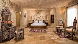 Un dormitorio con una cama grande, muebles ornamentados y una pared de piedra con textura.