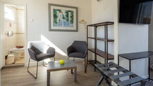 Un salon moderne comprenant un canapé, une table basse, un téléviseur et une bibliothèque.