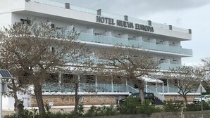 A multi-story hotel named "HOTEL NUEVA EUROPA" with a modern architectural design, featuring balconies and a stone facade. - Hotel Nueva Europa (Torredembarra)