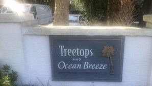 A sign for 'Treetops and Ocean Breeze' with a palm tree decoration. - Ocean breeze treetops 2 bdrm walk to beach tennis dog friendly w/d permit#070894 (Hilton Head Island)