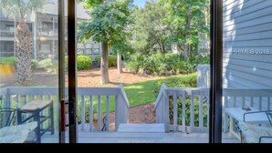 A view from a room with a glass door leading to an outdoor deck. - Ocean breeze treetops 2 bdrm walk to beach tennis dog friendly w/d permit#070894 (Hilton Head Island)