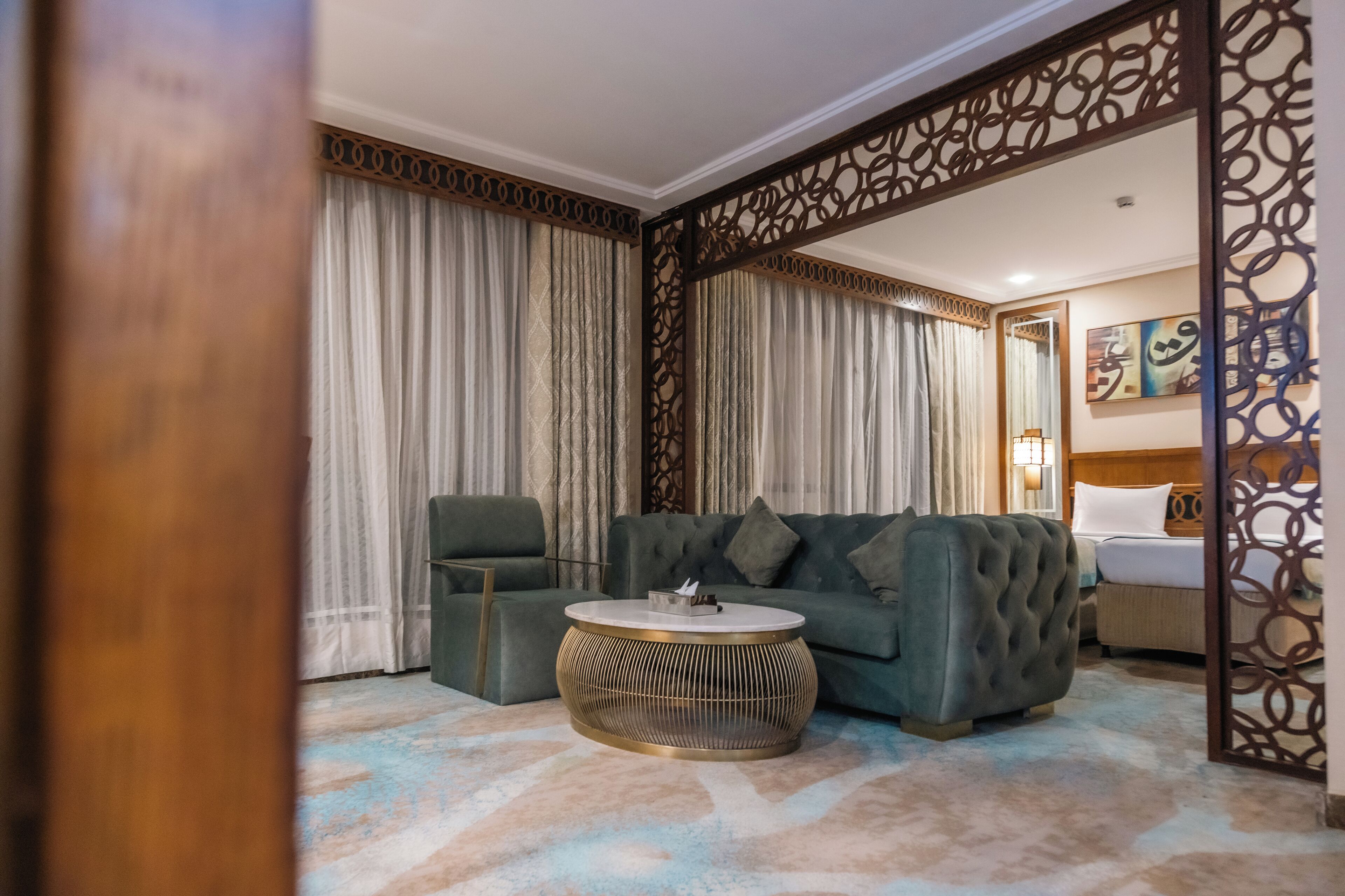 Una sala moderna con un sofá, un sillón y una mesa de centro redonda.