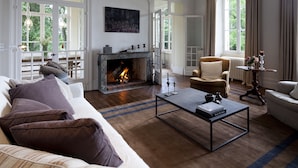 A living room with a fireplace, a sofa, a coffee table, and a chair.