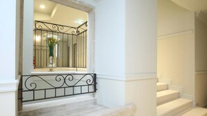 Una escalera con peldaños blancos y barandilla de metal negro.