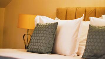 Ein Hotelzimmer mit Bett, Kissen, Lampe und Kopfteil.