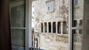 Vista de un edificio de piedra con ventanas de arco y barandilla de balcón.