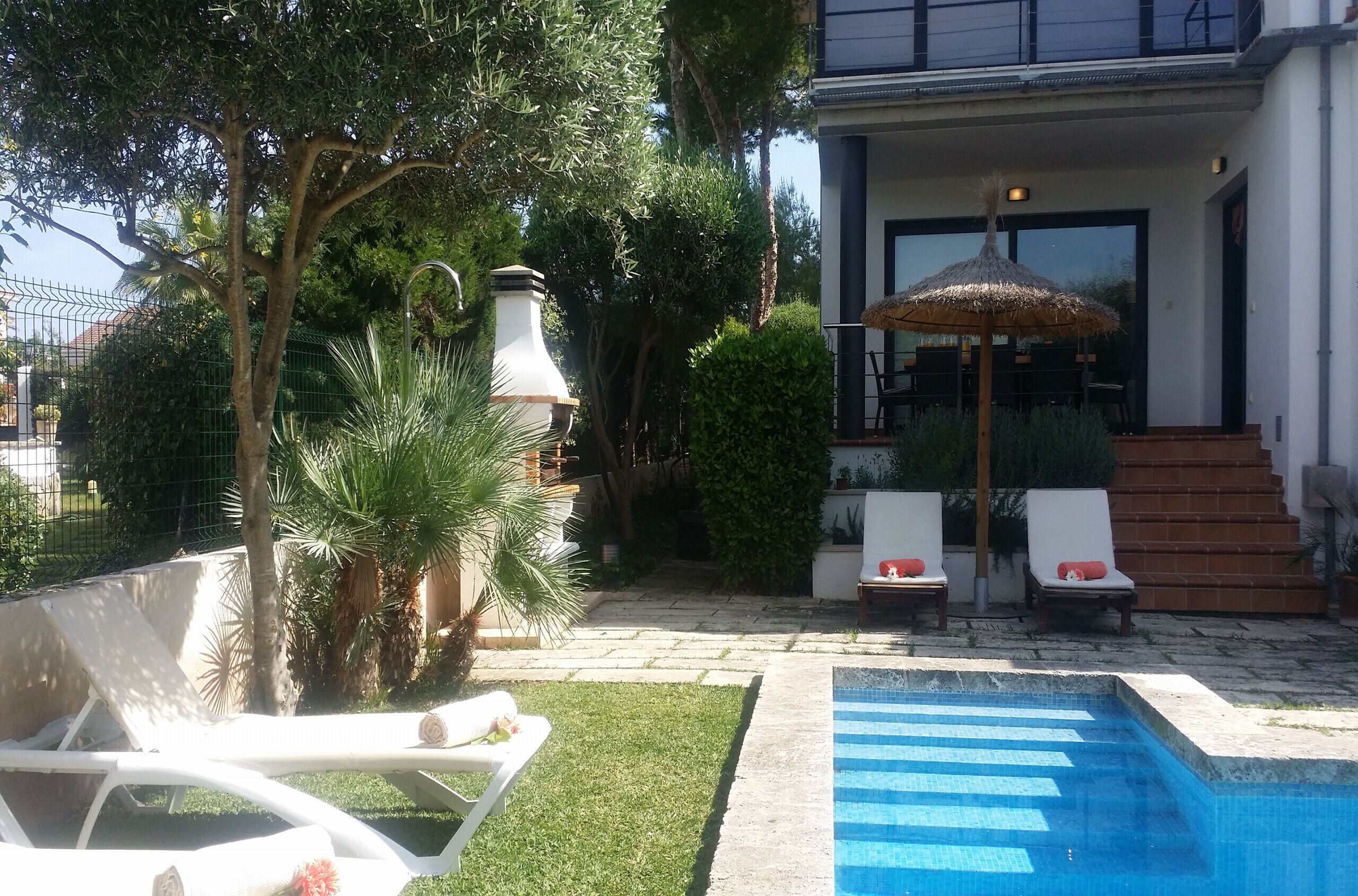 Ett poolområde med solstolar och en pergola.