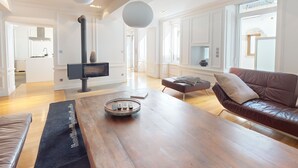 A spacious living room with a wooden coffee table, a brown leather sofa, and a fireplace.