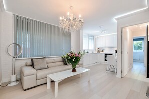 Ein modernes Wohnzimmer mit einer Couch, einem Couchtisch und einer Kronleuchter.