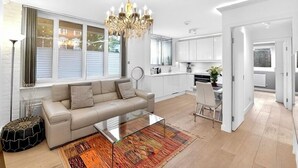 Een moderne woonkamer met een bank, salontafel en een kroonluchter.