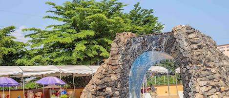 Una piscina al aire libre, sombrillas, sillones reclinables de piscina