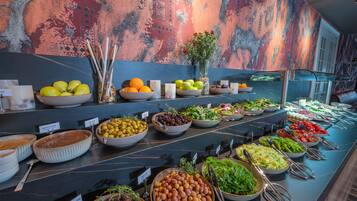 A buffet with various food items and a decorative wall.