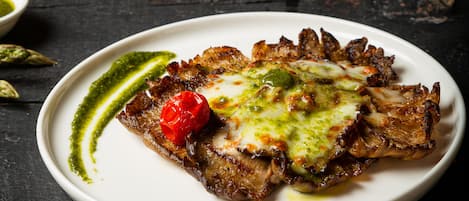 Un piatto di cibo con un cucchiaio di salsa che viene versato sopra.