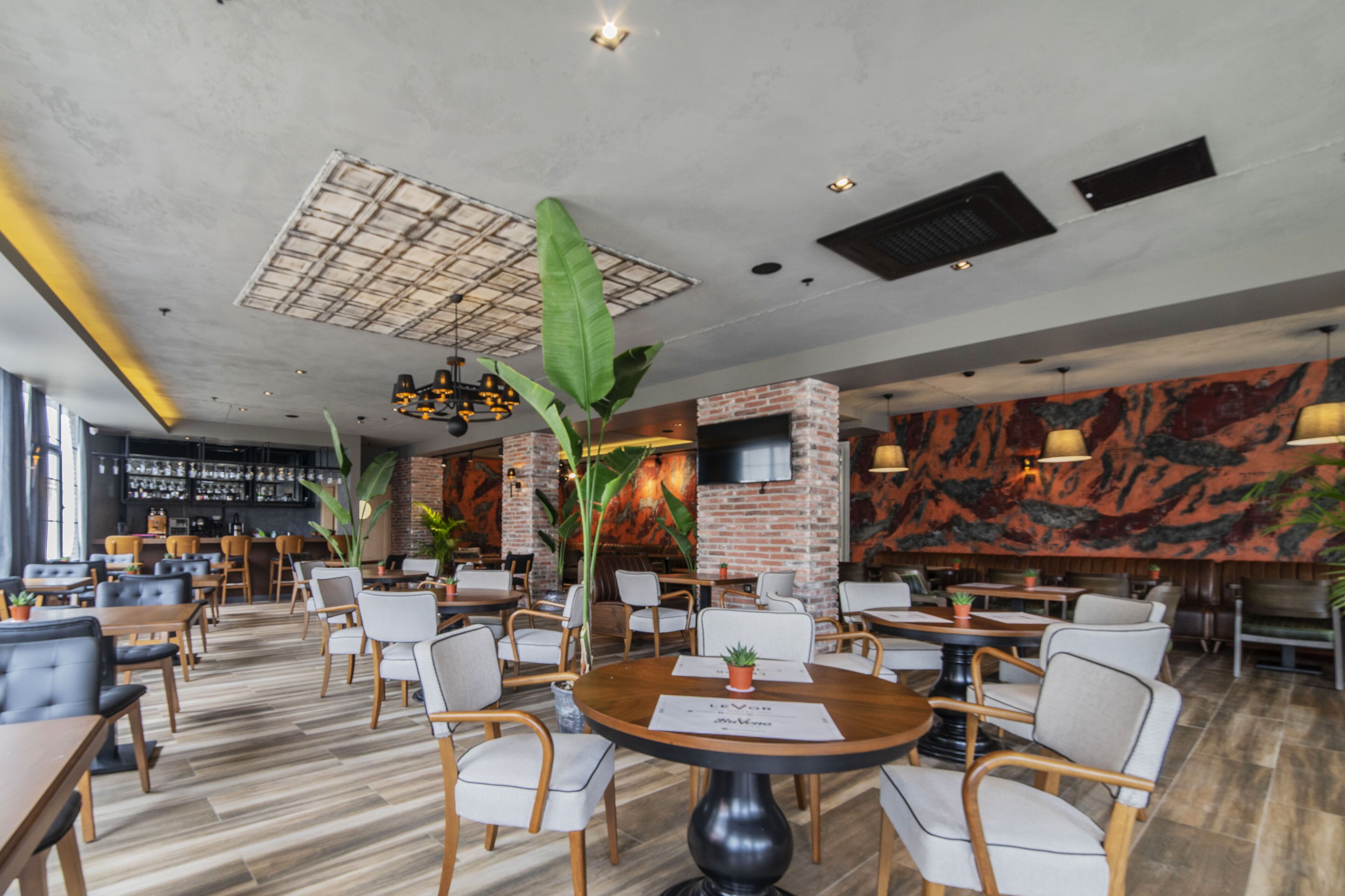 Un restaurante moderno con paredes de ladrillo, mesas y sillas de madera.