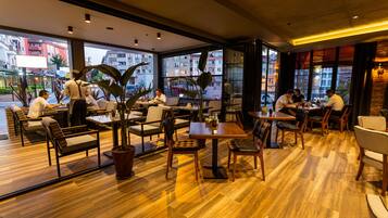 Un restaurante moderno con suelo de madera y amplios ventanales que ofrecen vistas a la ciudad.