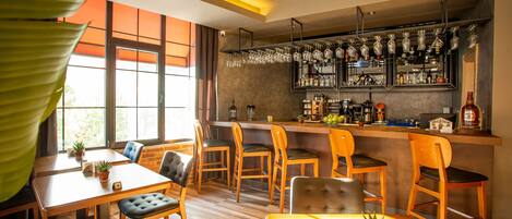 Un restaurant avec des meubles en bois, un coin bar et de grandes fenêtres.