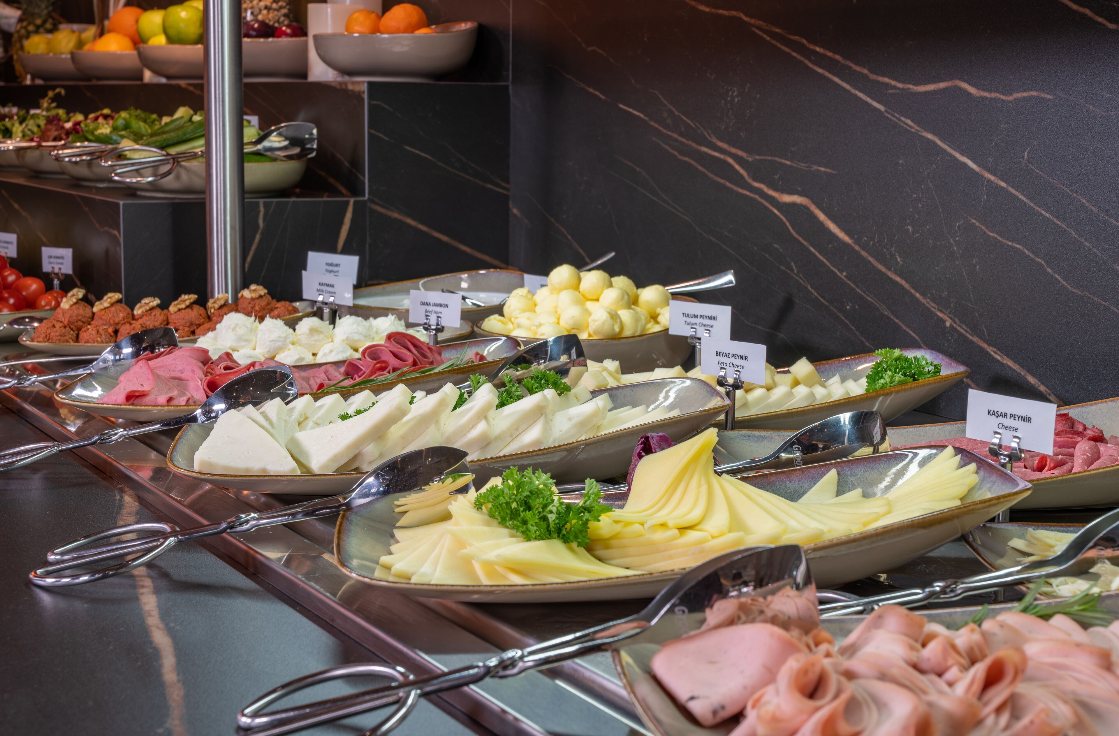 A buffet with various food items and utensils.