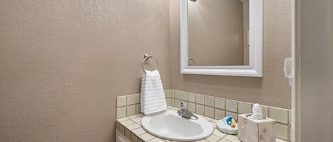 A bathroom with a white sink, a mirror, and a towel rack.