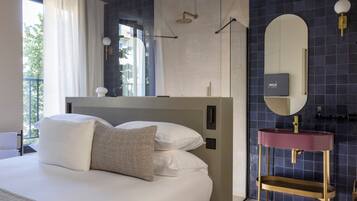 Un dormitorio moderno con una cama grande, un tocador con espejo y vistas al exterior.