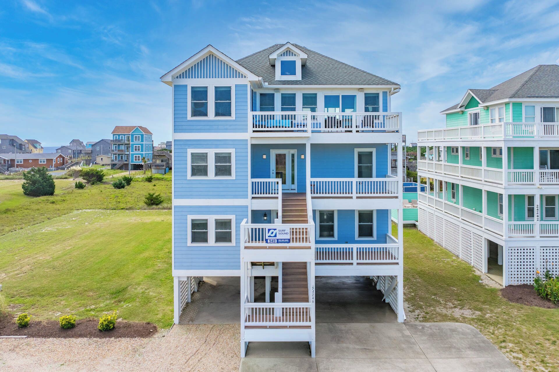 A multi-story building with a blue exterior, multiple balconies, and a visible '949' sign.