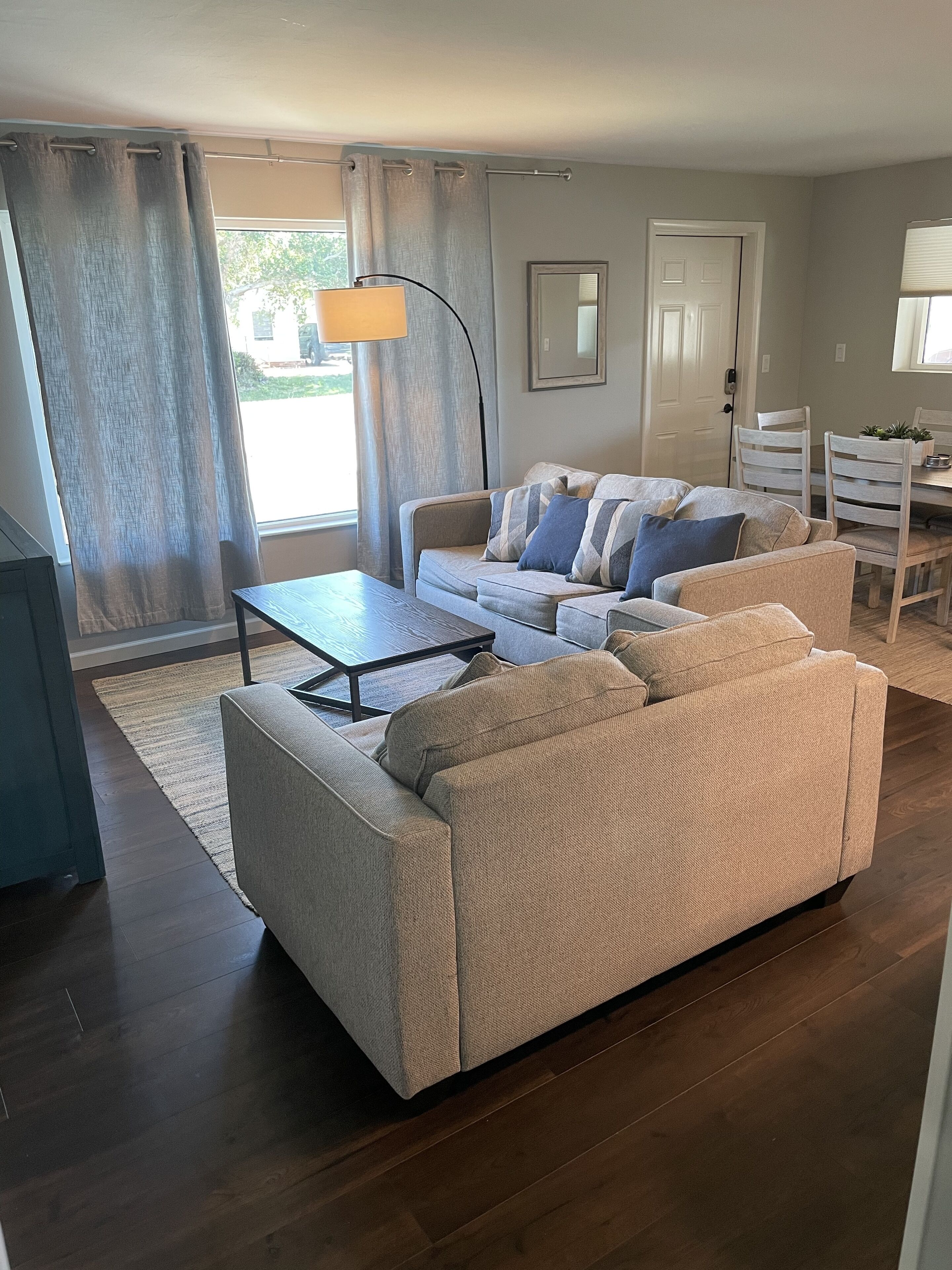Un salon comprenant un canapé, une table basse et un coin repas avec des chaises et une table.