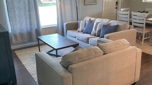 Una sala de estar con un sofá, una mesa de centro y un comedor con sillas y una mesa.