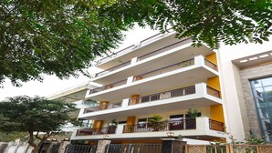 A multi-story residential building with balconies, a gated entrance, and a modern architectural design.