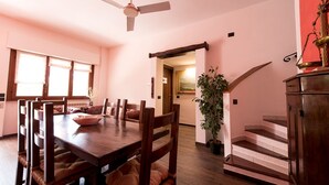 A dining area with a wooden table and chairs, a ceiling fan, a staircase, and a potted plant. - VILLA IARA IN CERVETERI WITH PRIVATE SWIMMING POOL (Cerveteri)
