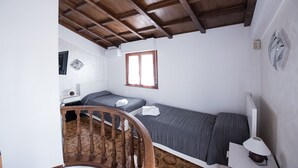 A small, single-room accommodation with a wooden ceiling, a bed, a desk, and a chair. - VILLA IARA IN CERVETERI WITH PRIVATE SWIMMING POOL (Cerveteri)