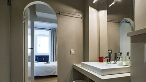 Ein modernes Badezimmer mit Waschbecken, Spiegel und einer kleinen Fußbank.
