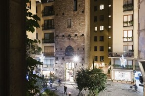 Un immeuble à plusieurs étages doté d’une cour intérieure, de balcons et comprenant un mélange d’espaces résidentiels et commerciaux.