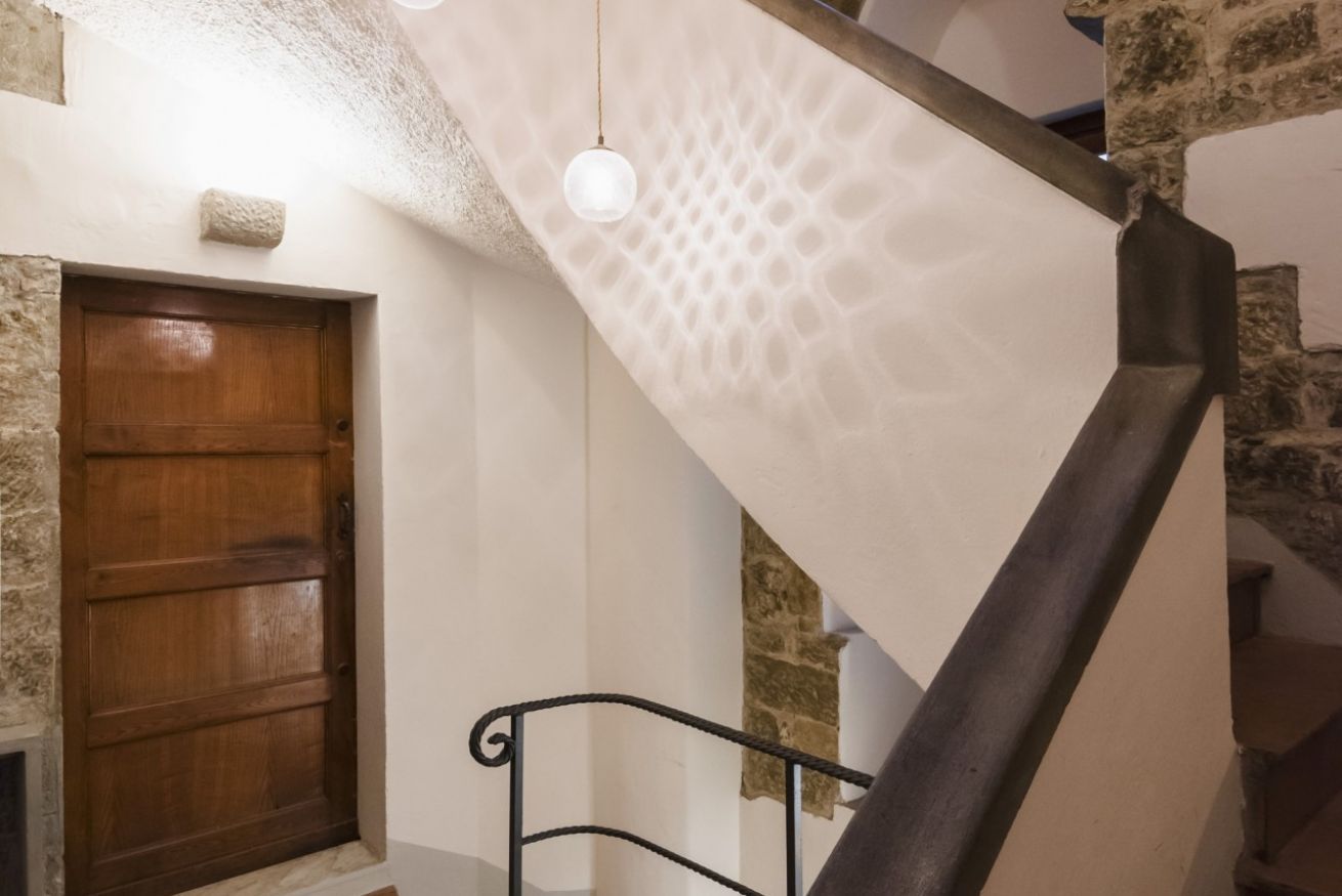 A staircase with a wooden door and stone walls.