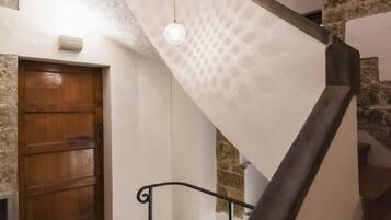 A staircase with a wooden door and stone walls.