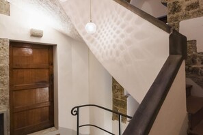 Eine Treppe mit einer Holztür und Steinwänden.