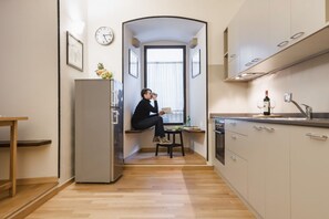 Une cuisine de taille réduite, équipée d’un réfrigérateur, d’un évier et d’une fenêtre.