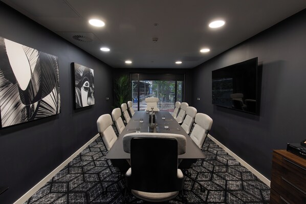 A conference room with a long table, chairs, and artwork on the walls. - CitySuites 2 Aparthotel (Salford)
