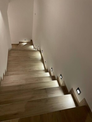 Eine Treppe mit Holzboden und Wandleuchten.