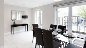 Un espace repas moderne avec une table en verre, des chaises noires et une décoration minimaliste.