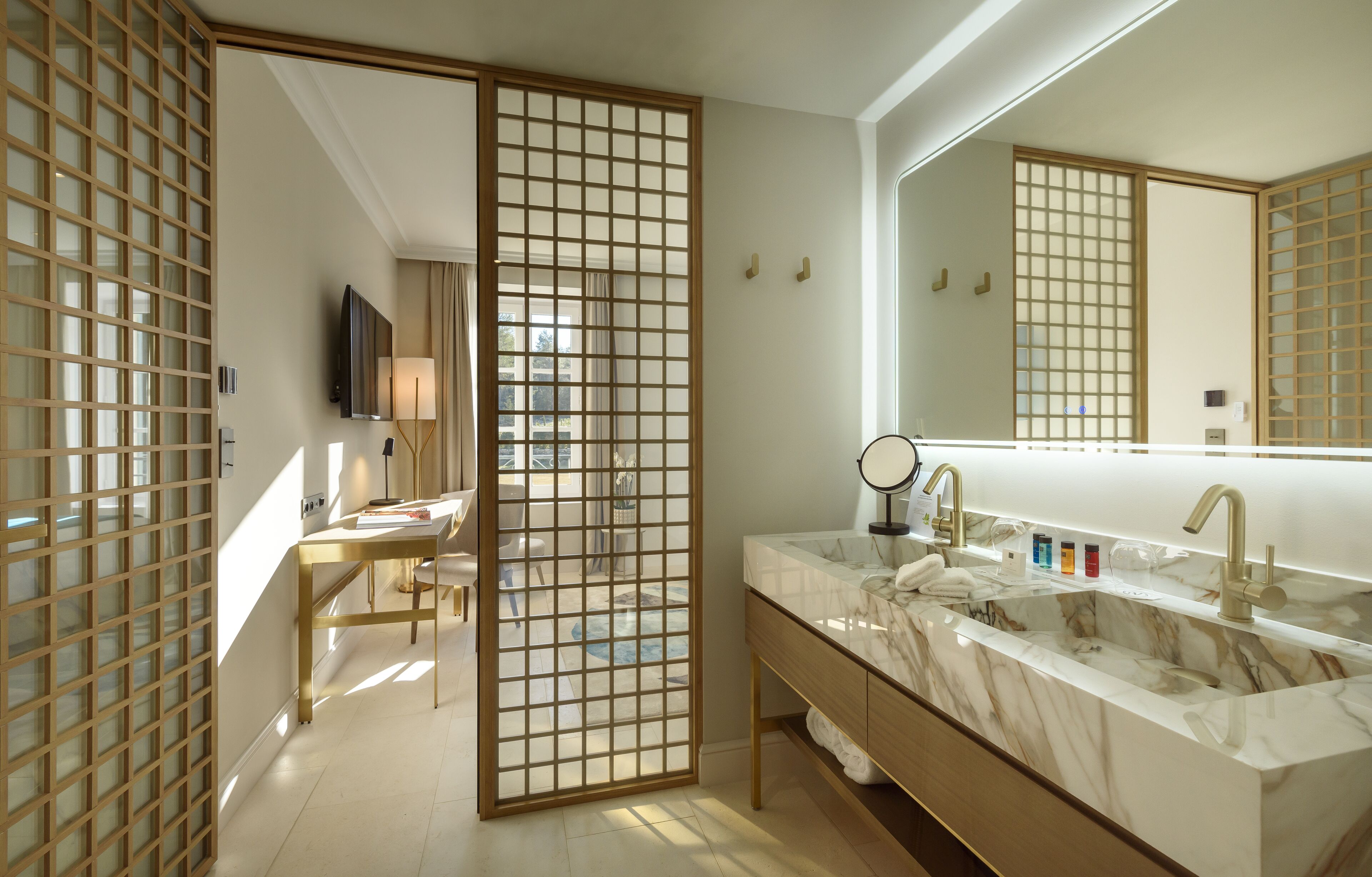 A modern bathroom with a large mirror, two sinks, and a sliding door.