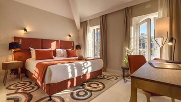 A hotel room with a large bed, a desk, and a chair.