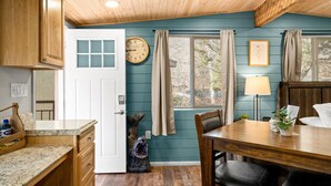 A kitchen with wooden cabinets, a granite countertop, a clock, and a window with curtains. - 18 Creekside Retreat (Sedona)