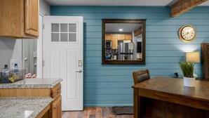 A kitchen with wooden cabinets, a white door, and a blue wall. - 15 Creekside Retreat (Sedona)