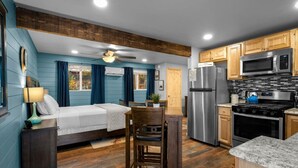 A compact kitchen with a refrigerator, microwave, stove, and wooden cabinets. - 15 Creekside Retreat (Sedona)