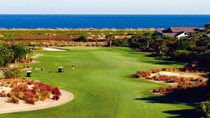 A golf course with a view of the ocean, surrounded by greenery and a few buildings. - 1315 Pelican Watch Villas Beach & Free Amenities - Sale 249 USD (Seabrook Island)