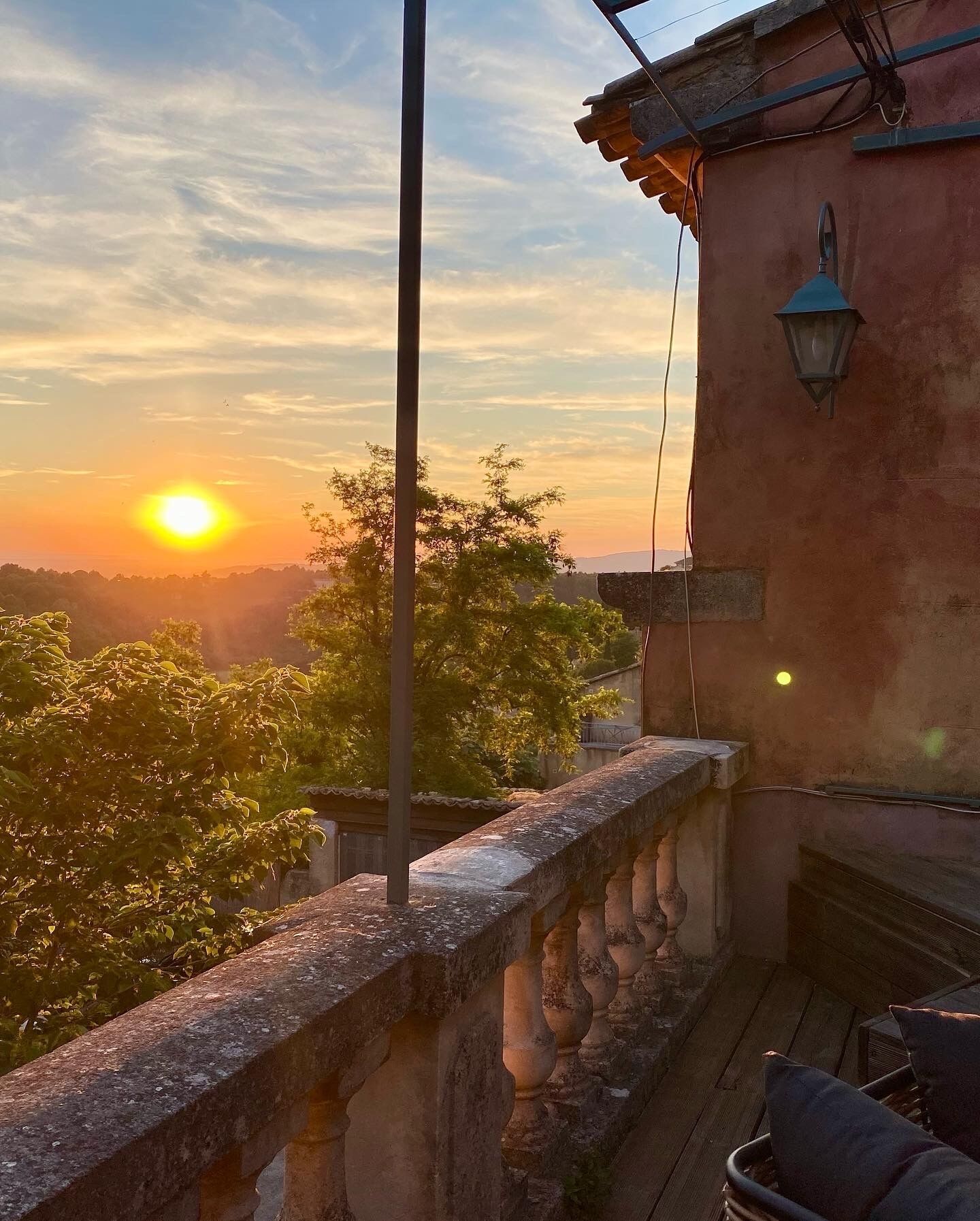 Ein Balkon mit Steinbalustrade mit Blick auf einen Sonnenuntergang.