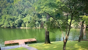 A serene lakeside park with a wooden dock and a paved walkway.