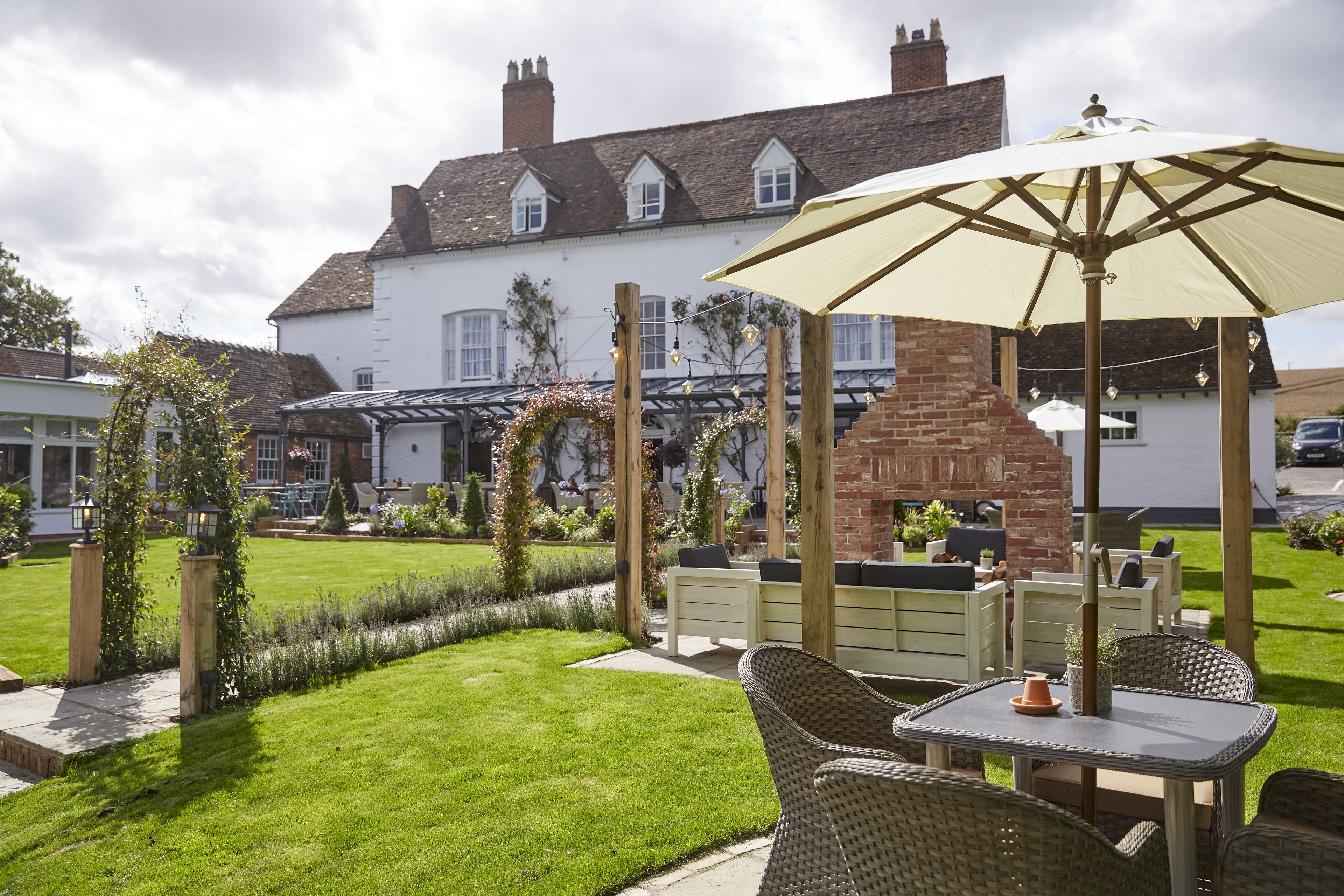 A patio area with wicker furniture, a table, and an umbrella.