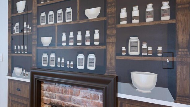 A kitchen with a brick fireplace, wooden shelves with kitchenware, and a white countertop. - Pharmacy Apartment | Luxury Monthly Stay Downtown (Charlottesville)
